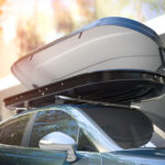 Auto so strešným boxom naloženým batožinou pripravené na rodinný výlet.